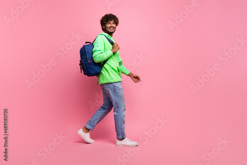 Full body length photo of steps young hipster student indian man wear rucksack behind going to study isolated on pink color background