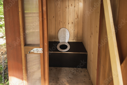 Clean wooden toilet outdoors in the forest in summer.
