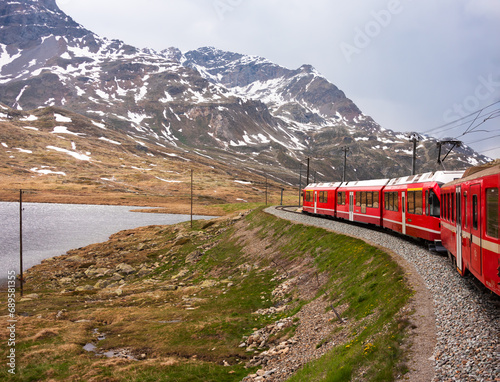 Red train going in beautiful landscape in Switzerland