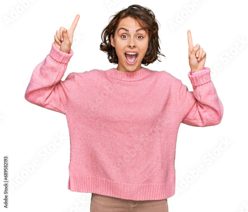 Young hispanic woman wearing casual clothes smiling amazed and surprised and pointing up with fingers and raised arms.