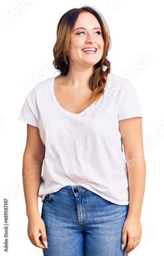 Young beautiful caucasian woman wearing casual white tshirt looking away to side with smile on face, natural expression. laughing confident.