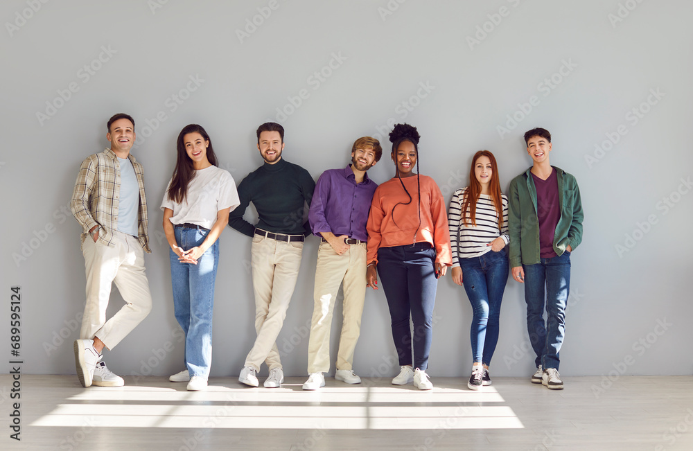 Obraz premium Diverse and happy multinational team stands in a united portrait, encapsulating the essence of friendship, smart collaboration, and the positive spirit that radiates within this group of people.