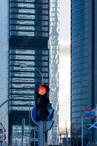 Red traffic light in a financial district, symbolizing urban control and business pause amidst the city's hustle photo