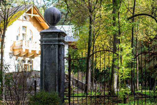 Принти на полотні Decorative gate with an antique column standing in front of an old manor house