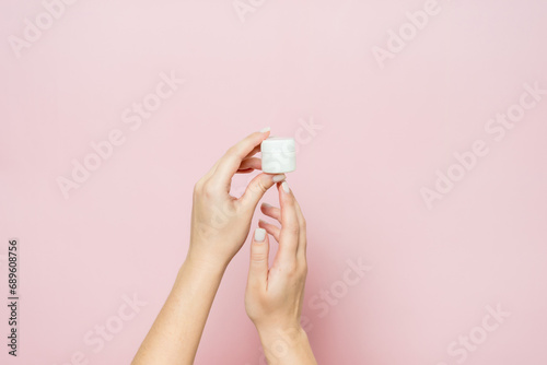 White jar or bottle with cream (ointment) in woman's hands. Facial care, bottle with cosmetic product