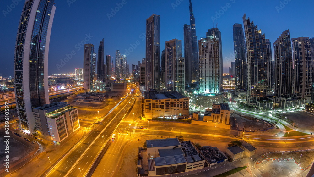 Aerial panorama of Dubai Downtown skyline with many towers night to day timelapse.