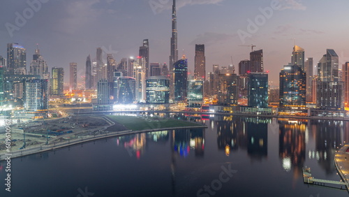 Aerial view to Dubai Business Bay and Downtown with the various skyscrapers and towers night to day timelapse