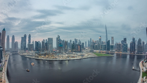 Aerial view to Dubai Business Bay and Downtown with the various skyscrapers and towers day to night timelapse