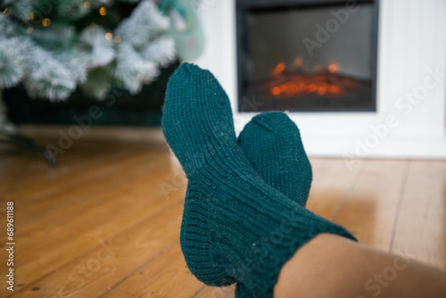 woman in wool socks warming in front of firepalce photo