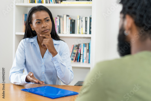 Skeptical latin american businesswoman talking with client