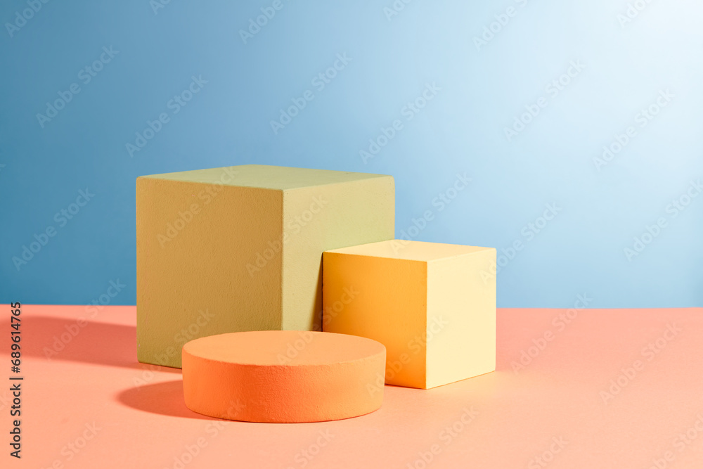 Fototapeta premium Three podiums in round and cube shaped are decorated against blue background. Pastel minimal wall scene collection. Modern platform for product display presentation