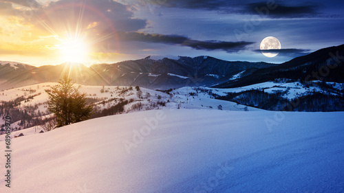 mountainous winter landscape in morning light. solstice scenery with snow covered rolling hills in the distance beneath a sky with sun and moon. day and night time change concept photo