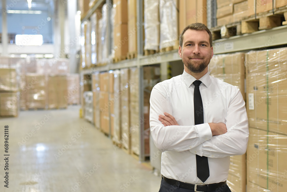 portrait friendly businessman/ manager in suit working in the warehouse of a company portrait friendly businessman/ manager in suit working in the warehouse of a company