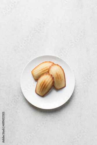 vanilla madeleines on a white plate, plain french vanilla madeleine cake or cookies
