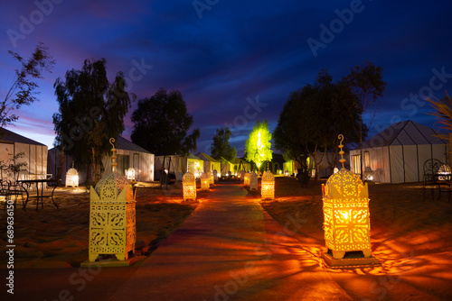 Luxury camp in the Sahara desert, with lights and the typical Haimas. Photo taken at dusk.