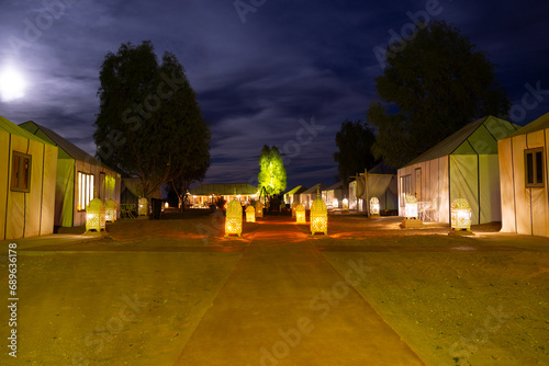 Luxury camp in the Sahara desert, with lights and the typical Haimas. Photo taken at dusk.