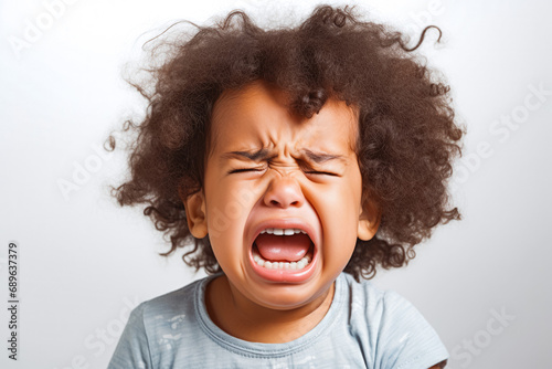 Cute little baby mixed race, afro american crying and screaming isolated on white background. Close up. Sad and in pain. photo