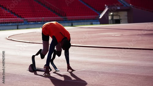 Asian para-athletes with prosthetic blades sprint on a running track at stadium.