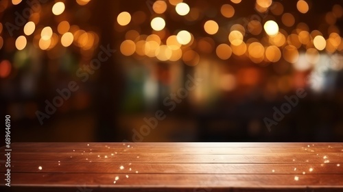 The empty wooden table top with blur background of restaurant at night. Exuberant image. 