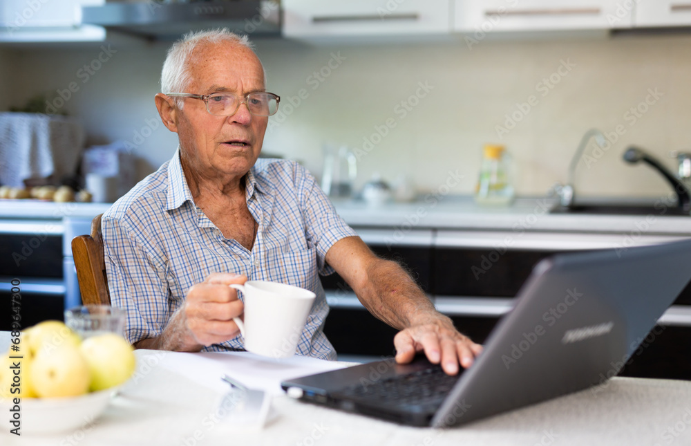 Old man learning to use laptop at home Old man learning to use laptop at home