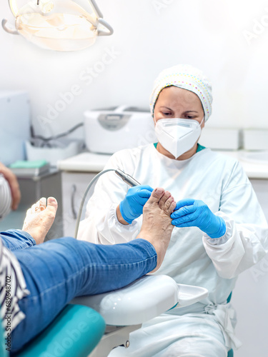 Female podiatrist doing chiropody in her podiatry clinic. Selective focus