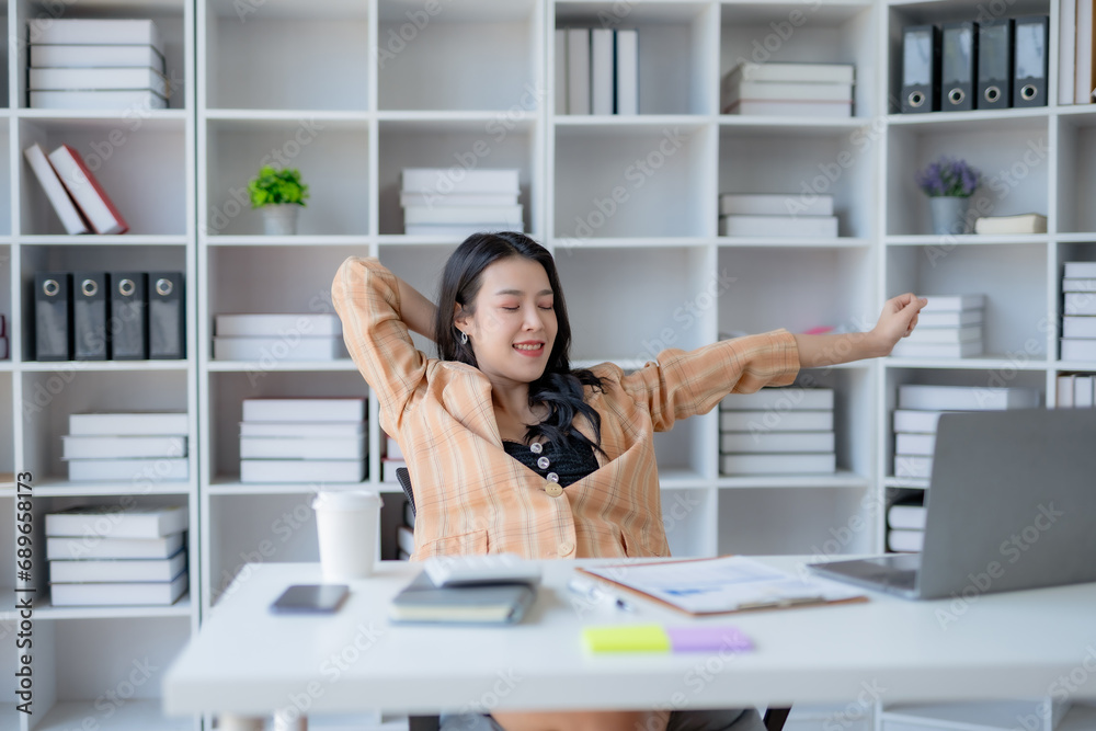 Young Asian woman employee relaxing after working in the office. Young Asian woman employee relaxing after working in the office.