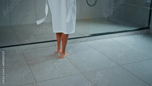 slim woman dressed white bathrobe in bathroom female undressed and going into shower cabin slow motion