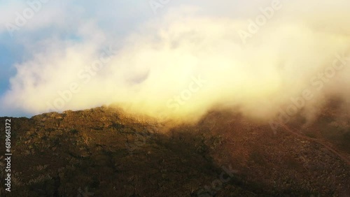 Aerial drone view of mount Maido with floating clouds at golden hour, Saint - Paul, Reunion. photo