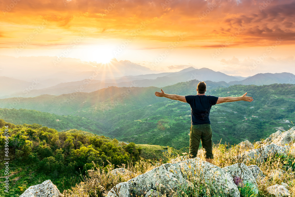 Fototapeta premium happy man watching amazing highland evening sunset, person delight with nature landscape