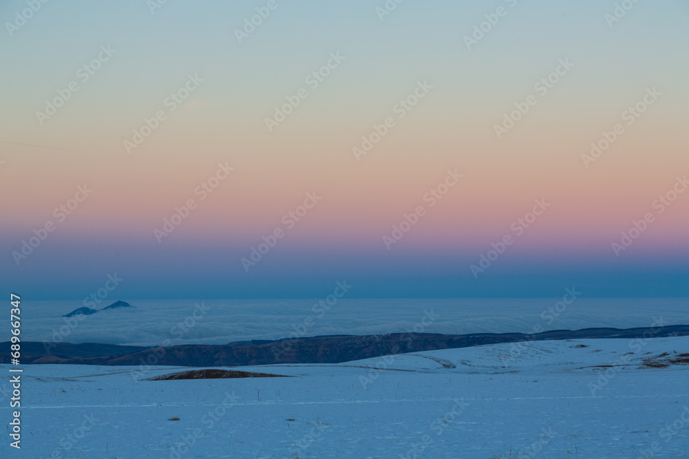 Sunset in snowy valley in Caucasus mountains, Russia. Background
