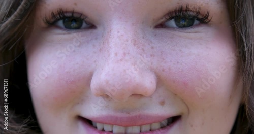 Close up of Womans Face, Girl opening her Beautiful blue azzure Eyes, Attractive Ginger. Natural Beauty with Freckles. Gorgeous woman with long Eyelashes and Attractive Appearance. Slow motion. photo