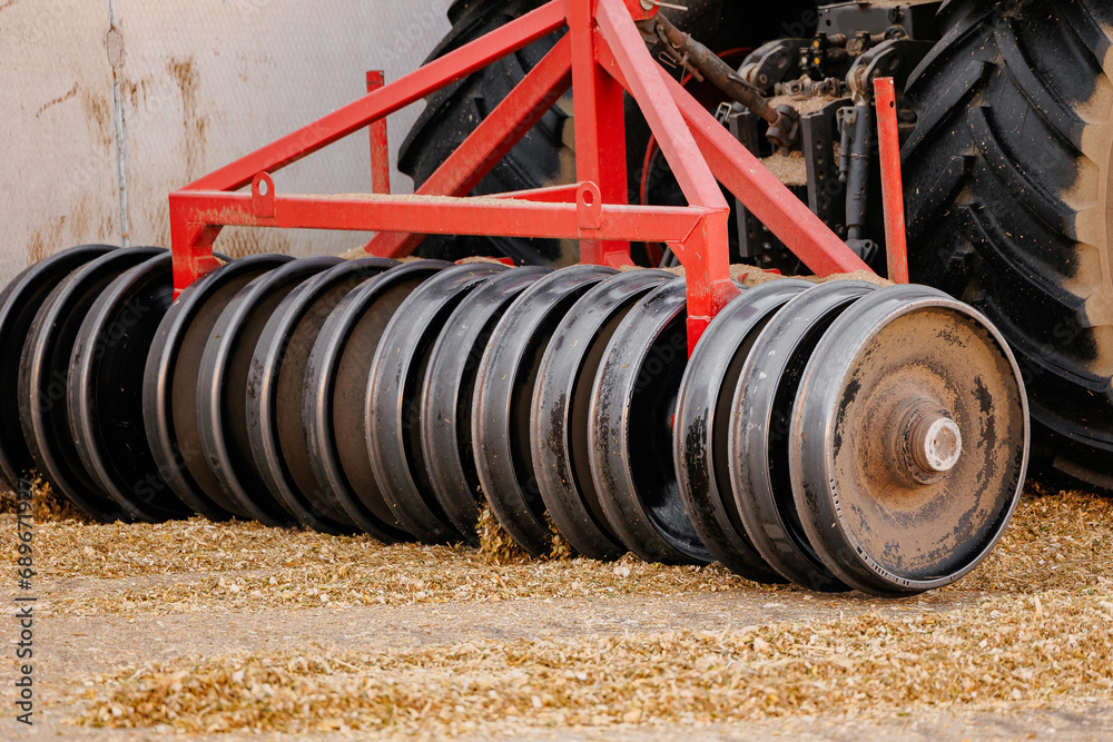 Tractor with heavy roller pressing silage on cattle farm, Fermented feed for food of cow. Compacting fresh harvest chopped maize for silo Tractor with heavy roller pressing silage on cattle farm, Fermented feed for food of cow. Compacting fresh harvest chopped maize for silo