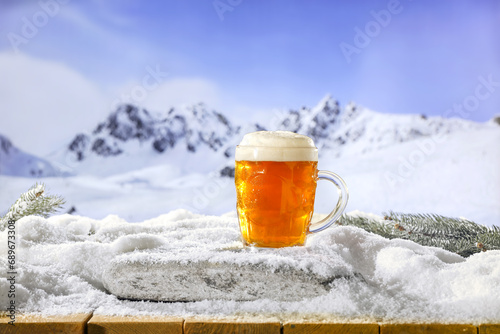 Fresh cold beer in glass and snow decoration. Background of table cover of frost and snow. Chrismtas time in mountains. Cold december time. 