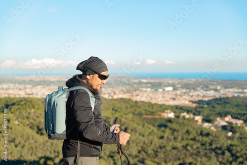 Middle-aged man contemplates the landscapes of the Garraf Natural Park while walking along the trails of a mountain.