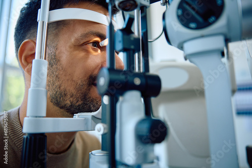 Fototapeta Naklejka Na Ścianę i Meble -  Young man during eyesight exam at ophthalmic clinic.