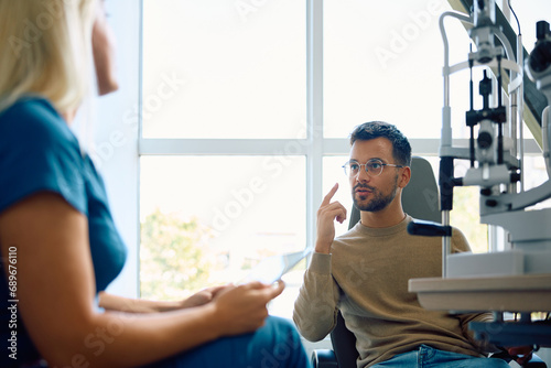 Young man communicating with his ophthalmologist at clinic.