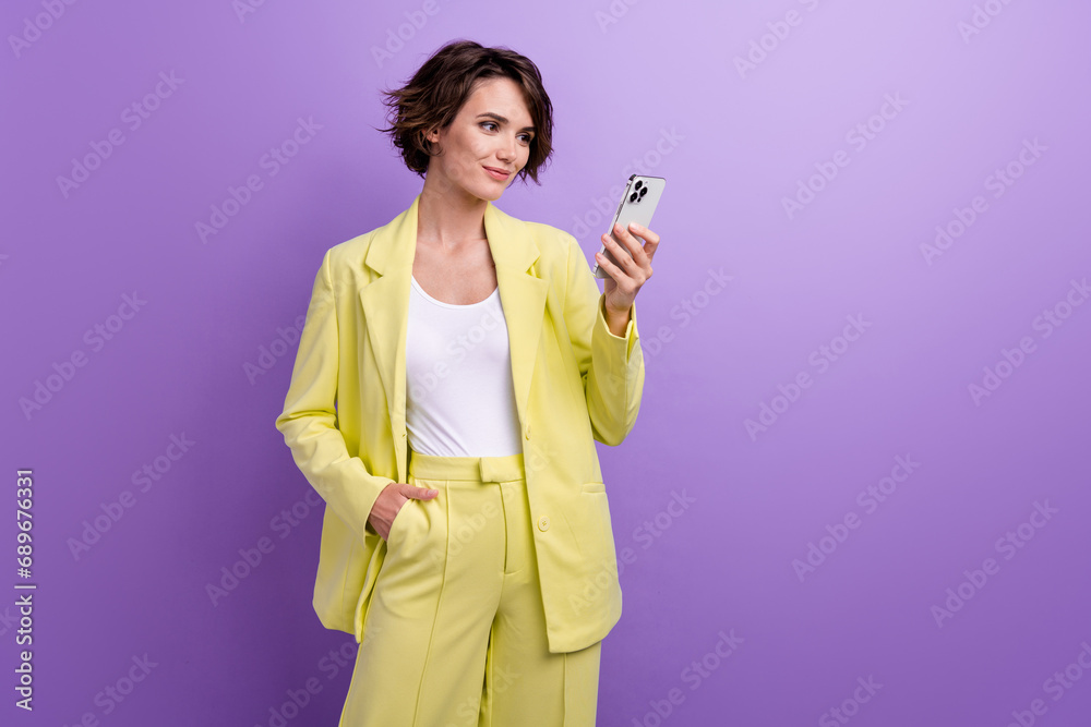 Photo confident gorgeous nice lady young age wearing lime suit holding smartphone find her bank account isolated on violet color background Photo confident gorgeous nice lady young age wearing lime suit holding smartphone find her bank account isolated on violet color background