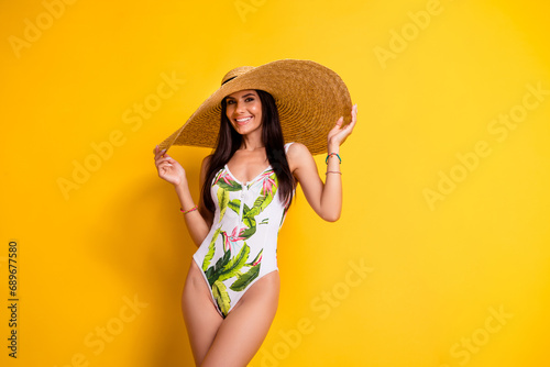 Photo of adorable pretty lady wear swimsuit big sun cap empty space isolated yellow color background photo
