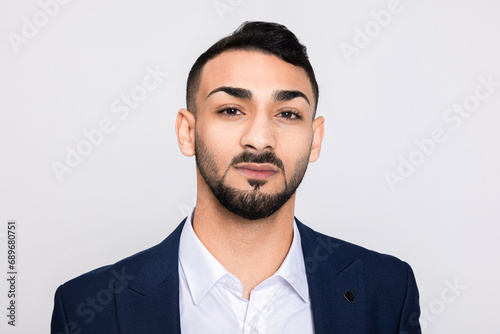 Portrait of serious concentrated in bad mood turkish man in studio isolated over grey background looking at camera smiling with white teeth buisneesman young successful guy. photo