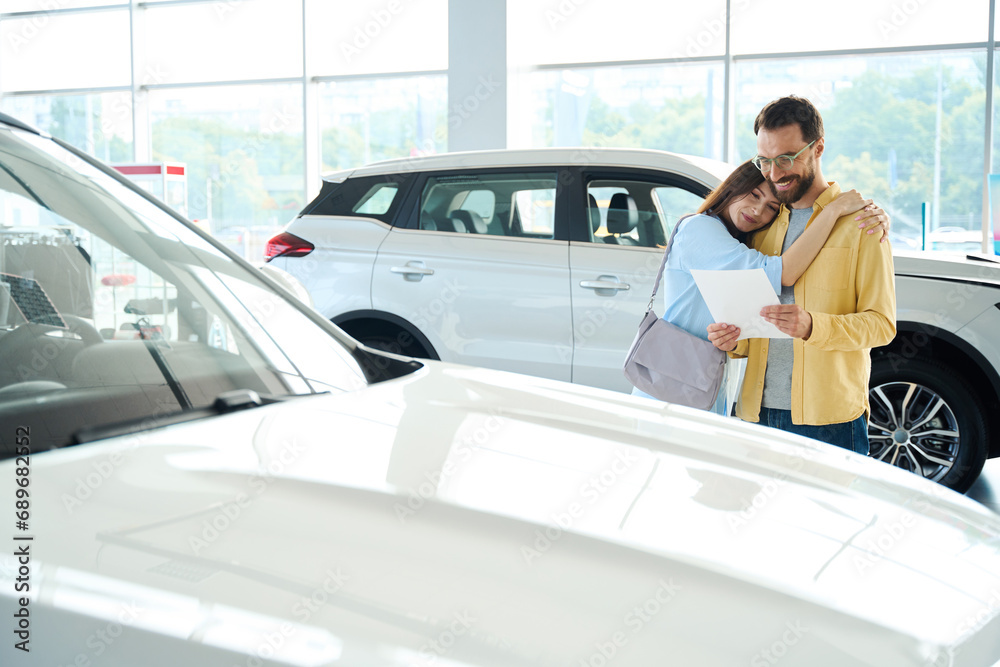 Photo of loving couple in car dealership Photo of loving couple in car dealership