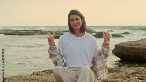 Mockup, street template of a white t-shirt on a young beautiful girl against the background of the ocean and sunset.