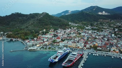 Limenas or Thassos City is the main city in Thassos Island , Greece , north-eastern Europe , aerial drone footage at sunset , showing the city , the harbor and the hills surrounding it. photo