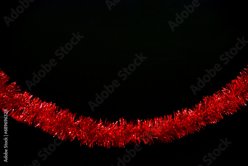 Red tinsel, glitter, trumpery on black color background photo