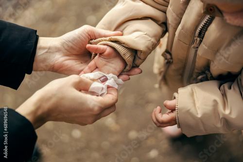 Close up of mother cleaning child's hands.