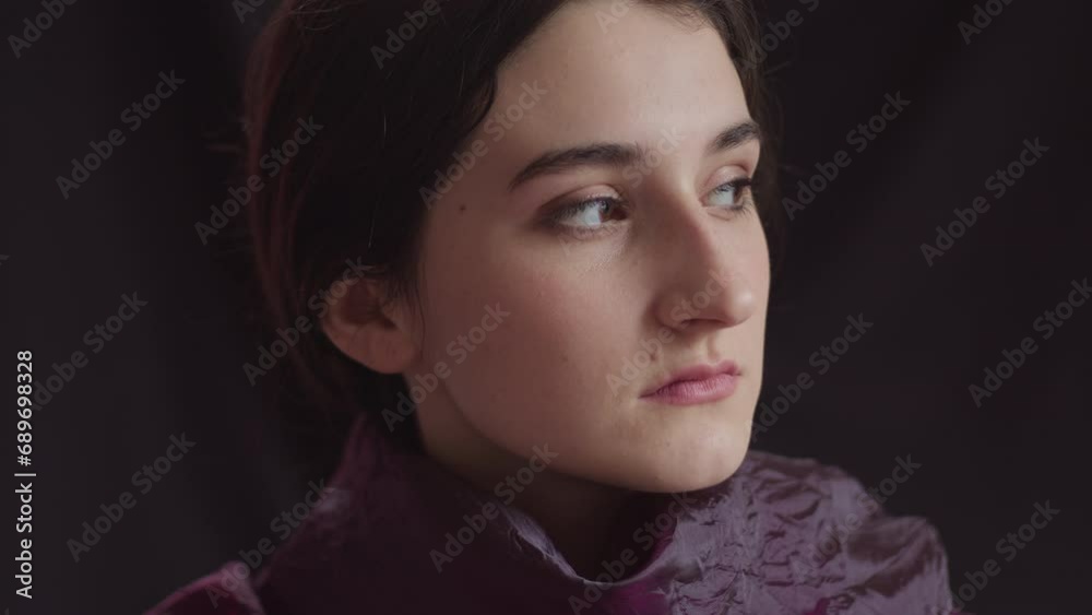 Portrait of a sad and pensive young woman on a black background. Portrait of a sad and pensive young woman on a black background.