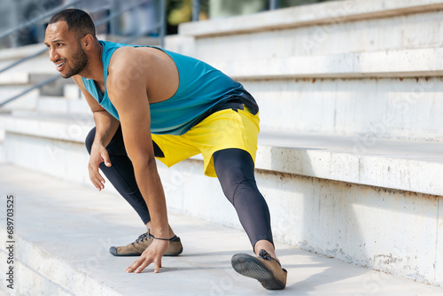 Young man in sportwear exercising and doing legs stretching