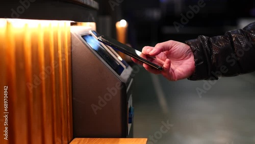 woman paying with her smart phone at an ATM machine photo