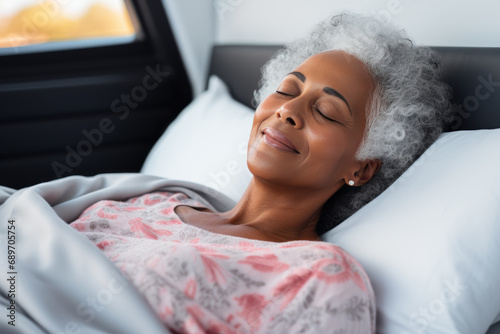 Senior afro american woman sleeping well on white pillow in bed