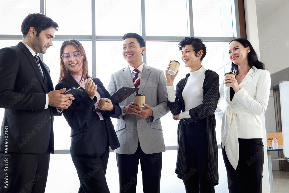 Five happy businesspeople, group of businessmen and businesswomen talking and drinking coffee during taking a break. Happy worker staff team at office workplace. People working together.