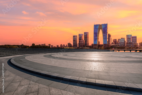 City square and skyline with modern buildings at sunset in Suzhou, Jiangsu Province, China.